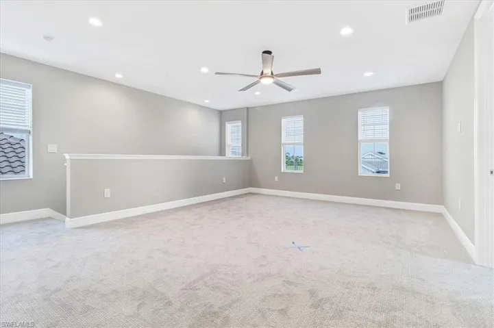 Empty room featuring a ceiling fan, recessed lighting, and light colored carpet