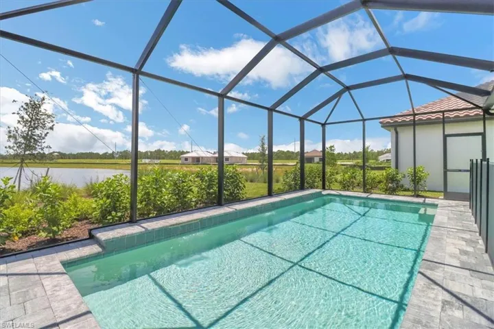 Outdoor pool featuring a sunroom and glass enclosure