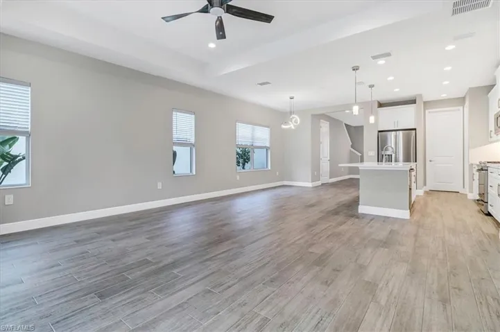 Unfurnished living room featuring a ceiling fan, recessed lighting, and light wood-style flooring