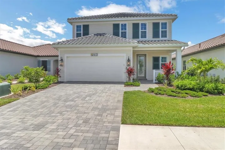 Mediterranean / spanish house with a garage, a tile roof, decorative driveway, and covered porch