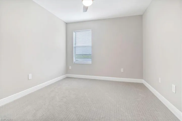 Empty room featuring light carpet and ceiling fan