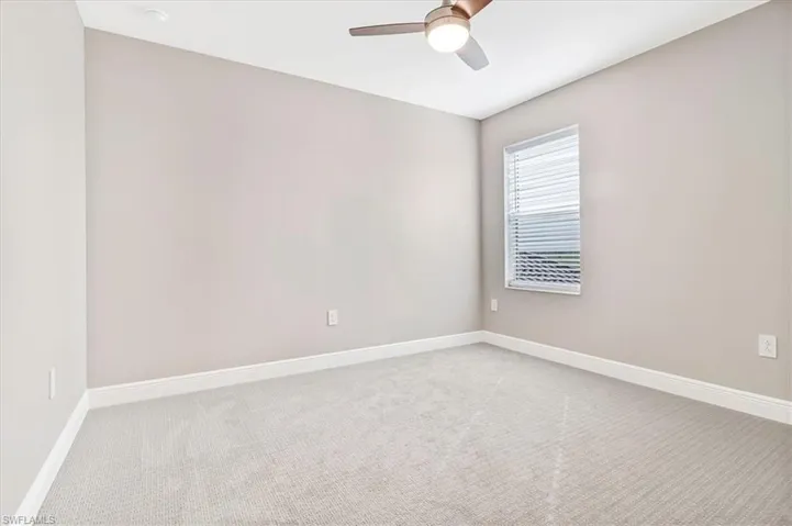 Spare room with light colored carpet and a ceiling fan