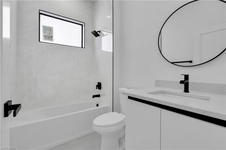 Full bathroom with toilet, vanity, tub / shower combination, and marble finish flooring