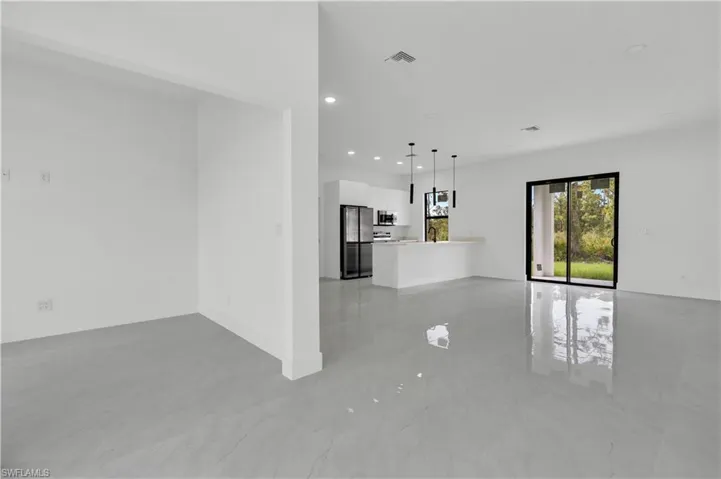 Unfurnished living room featuring recessed lighting and light marble finish flooring