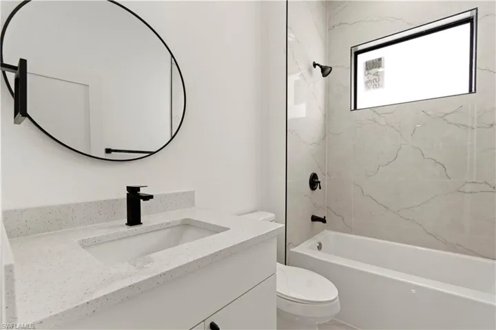Bathroom featuring toilet, vanity, and shower / bathtub combination