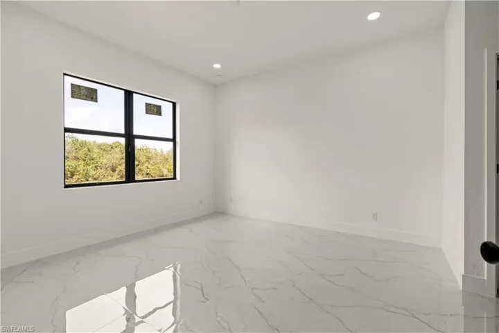 Unfurnished room with light marble finish flooring, baseboards, and recessed lighting