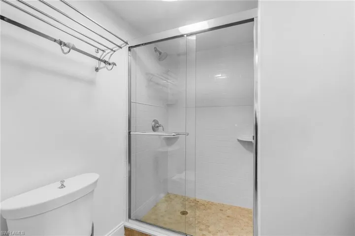 Bathroom featuring an enclosed shower and toilet
