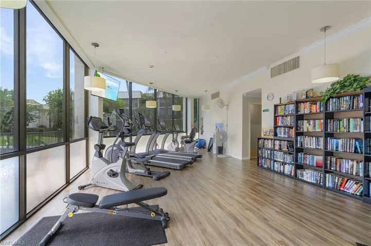 Gym featuring a wall of windows, hardwood / wood-style floors, and ornamental molding