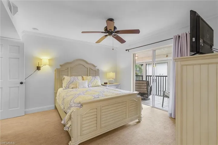 Carpeted bedroom featuring ceiling fan, ornamental molding, and access to exterior