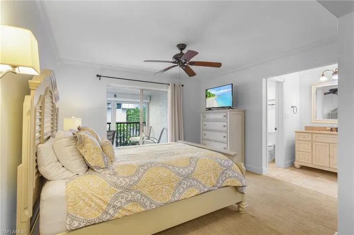 Bedroom with ceiling fan, connected bathroom, ornamental molding, light carpet, and access to exterior