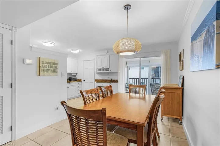 Tiled dining room featuring crown molding