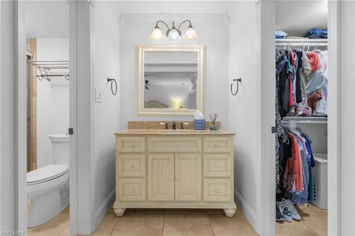 Bathroom featuring vanity, crown molding, toilet, and tile patterned flooring
