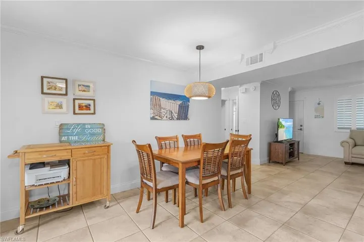 Dining space with ornamental molding and light tile patterned floors