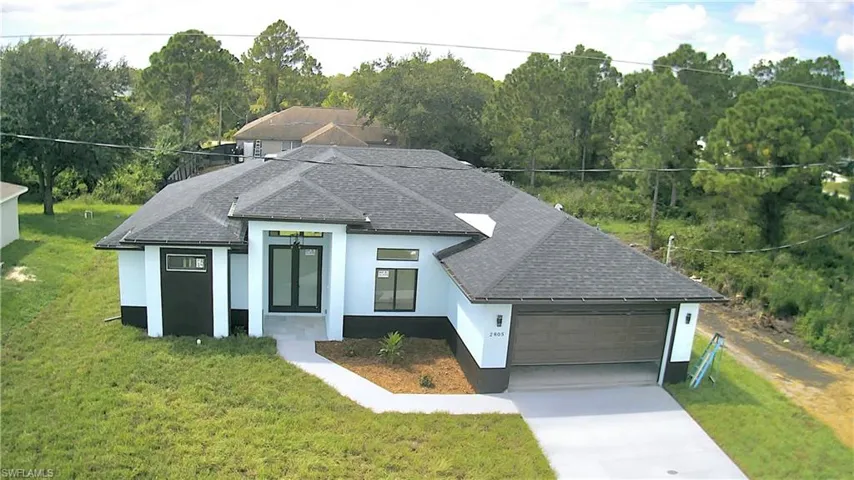 View of front of home featuring a front yard and a garage