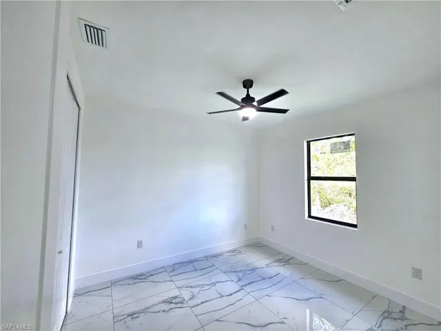 Spare room featuring ceiling fan and light tile patterned flooring