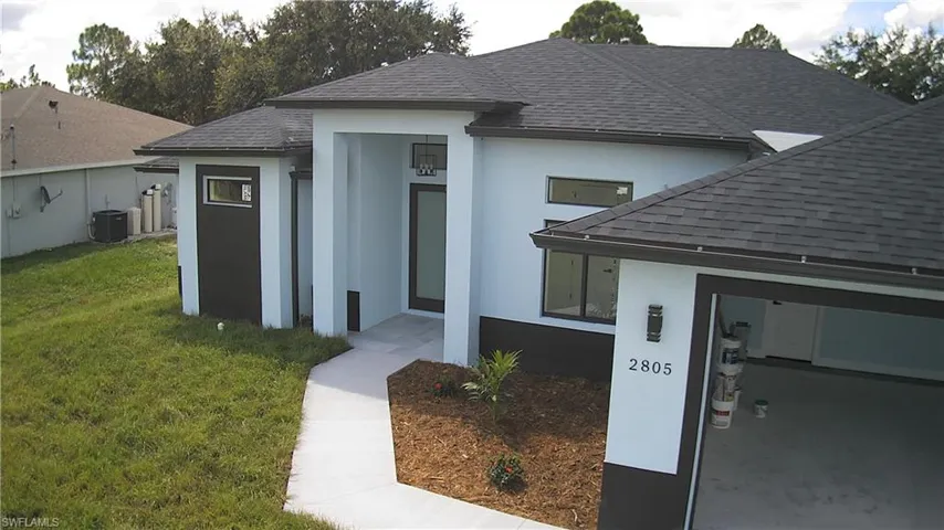 View of front of house with a front yard and cooling unit