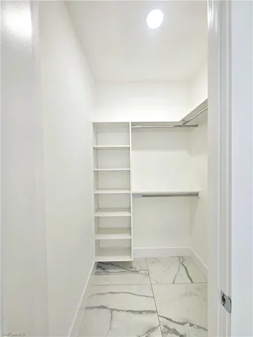 Walk in closet featuring light tile patterned flooring