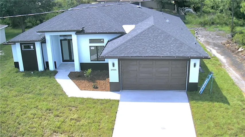View of front of property featuring a front lawn and a garage
