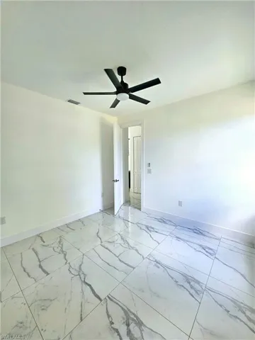 Spare room featuring light tile patterned floors and ceiling fan