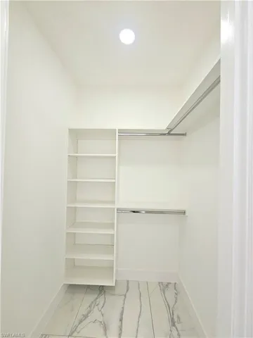 Walk in closet with light tile patterned floors