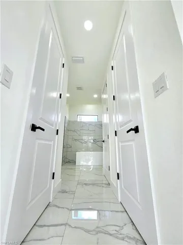 Hallway featuring light tile patterned flooring