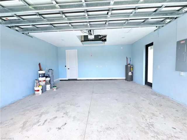 Garage featuring electric panel and electric water heater