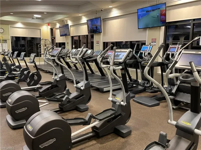 Gym featuring a raised ceiling and crown molding
