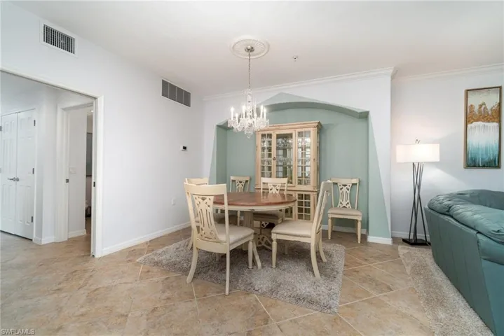 Dining area with crown molding and a notable chandelier