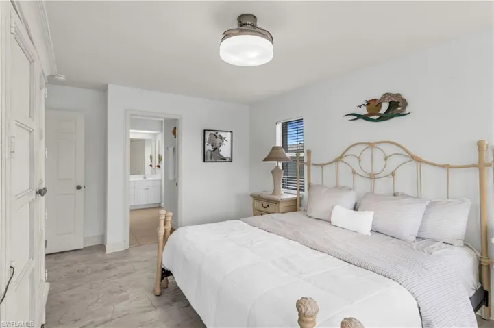 Bedroom with connected bathroom and baseboards