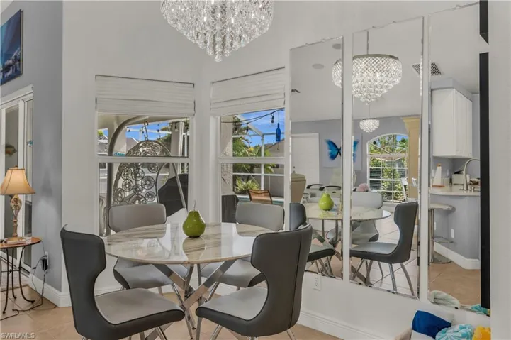 Dining space featuring hanging lights, light tile patterned floors, and a high ceiling