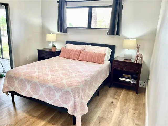 Bedroom featuring hardwood / wood-style flooring, multiple windows, and access to exterior