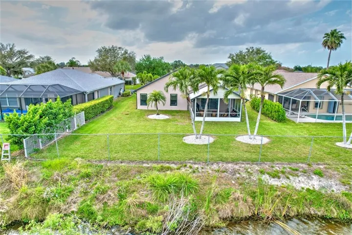 Back of house with a sunroom, a lanai, a fenced backyard, and stucco siding