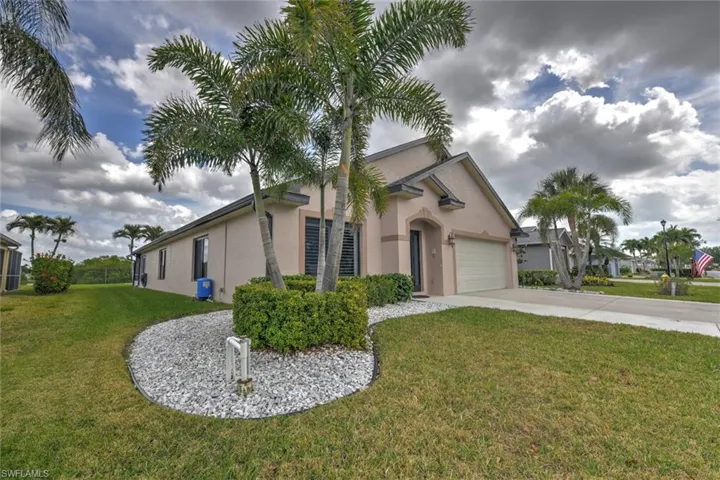 View of front of home featuring a front yard, driveway, stucco siding, and a garage