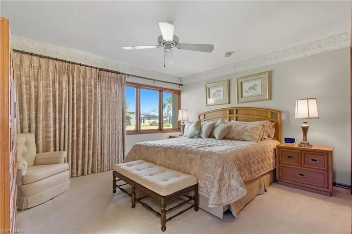 Carpeted bedroom featuring ceiling fan