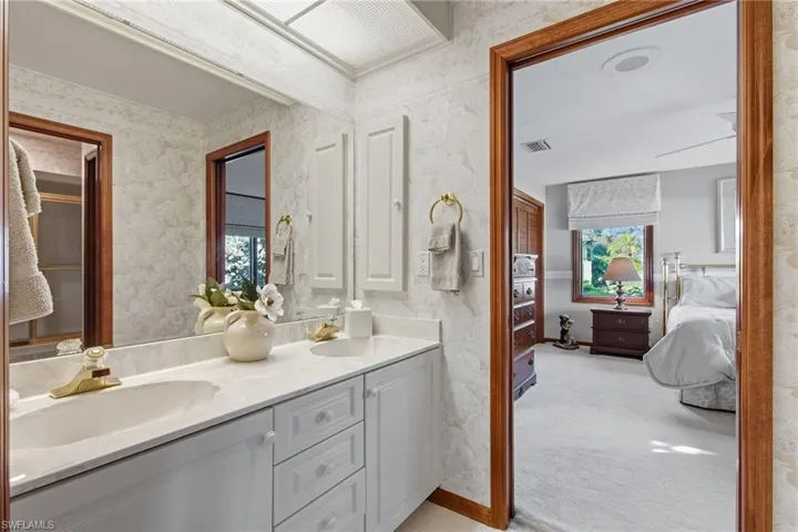 Guest Jack-n-Jill bath with dual vanities, cabinet storage, pocket doors.