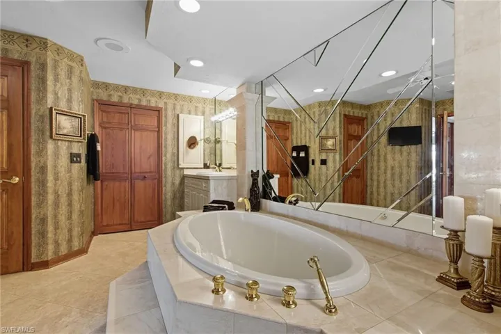Owner's bath featuring a large soaking tub, dual sinks, vanity and a linen closet.