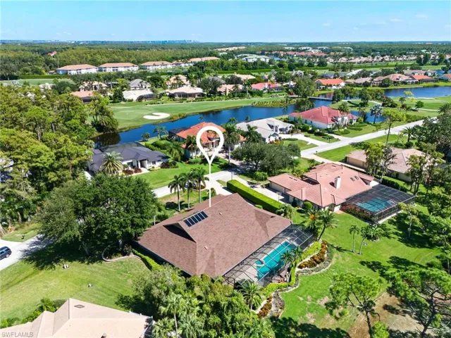 Aerial perspective of the home featuring a nearby lake and a golf course.