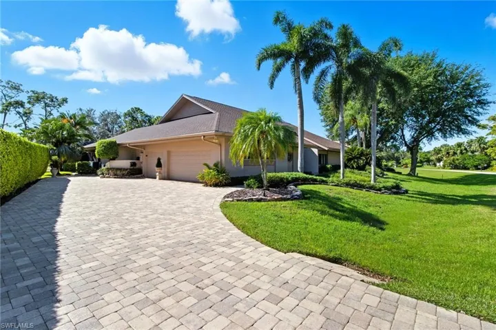 Large brick paver drive with entry to a 3-car garage.