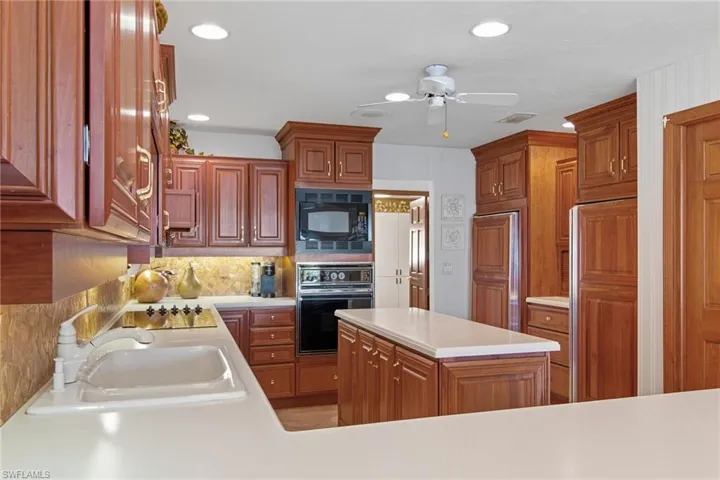 Kitchen features built-in refrigerator and freezer, prep island, pantry, lots of cabinet space.