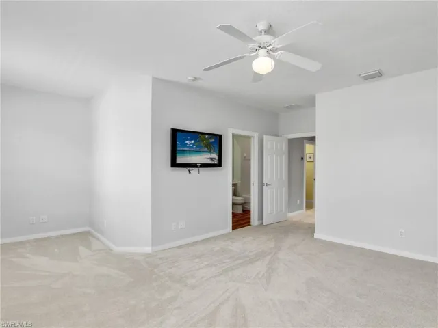 Spare room featuring light carpet and ceiling fan