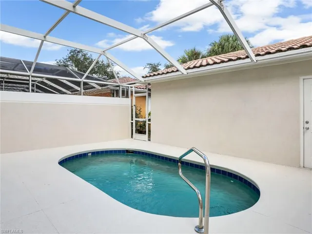 View of swimming pool with glass enclosure and a patio area