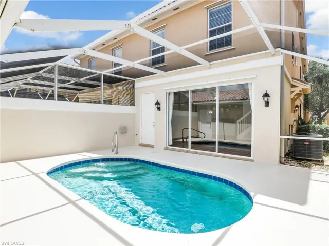 View of pool featuring cooling unit, a lanai, and a patio area