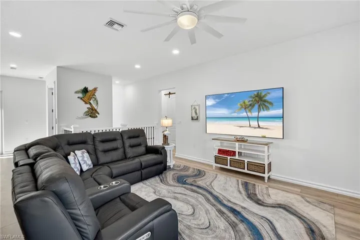 Living room with light wood-type flooring, recessed lighting, and ceiling fan