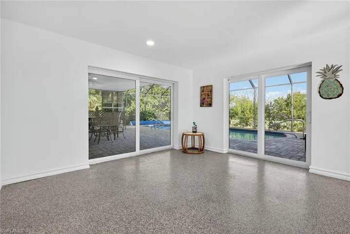 Spare room with a sunroom, speckled floor, plenty of natural light, and recessed lighting