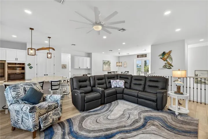 Living area featuring light wood finished floors, recessed lighting, and a ceiling fan
