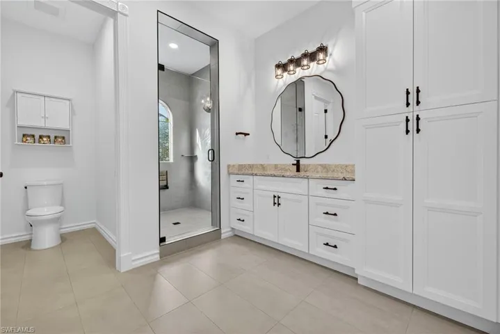 Full bath with vanity, light tile patterned floors, a shower stall, and recessed lighting