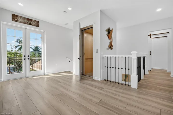 Elevator/Stair Landing featuring light wood-style floors, french doors, and recessed lighting