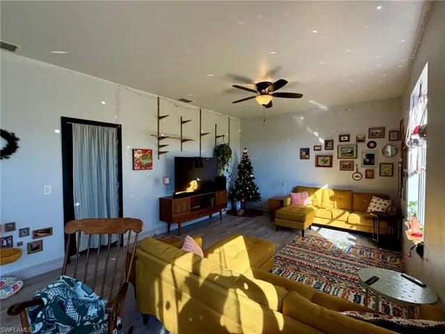 Living area with wood finished floors and a ceiling fan