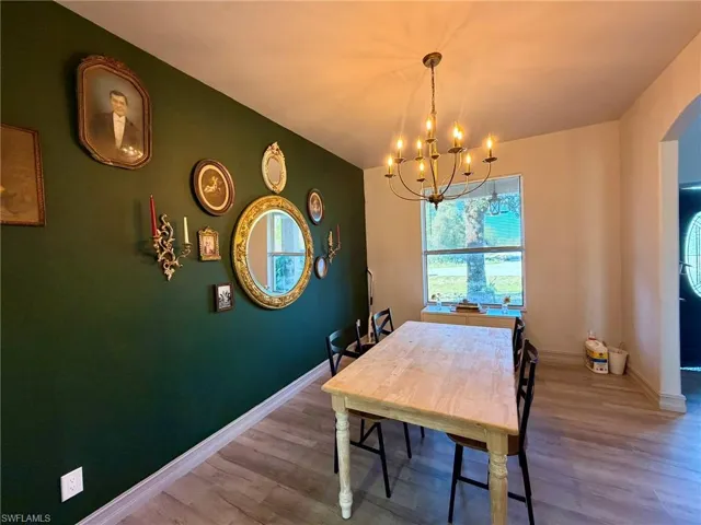 Dining space featuring a chandelier, plenty of natural light, and wood finished floors
