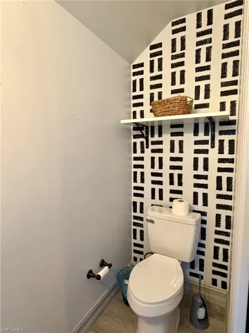 Bathroom featuring lofted ceiling and wood finished floors